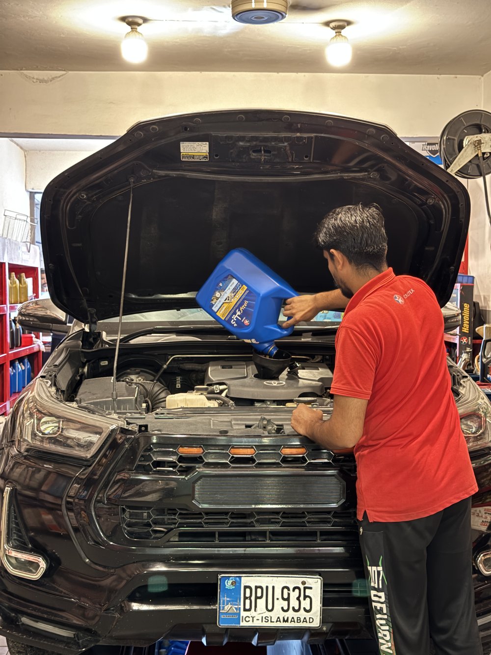 Lubri Care Xpress technician topping up genuine Caltex oil at G-8 Markaz
